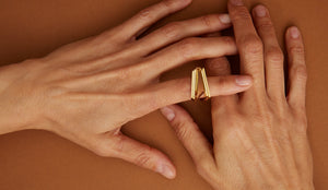 Gold ring with triangular cut citrine stone on model's hand