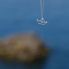 Load image into Gallery viewer, White gold chain necklace with little boat shaped pendant on seaside background
