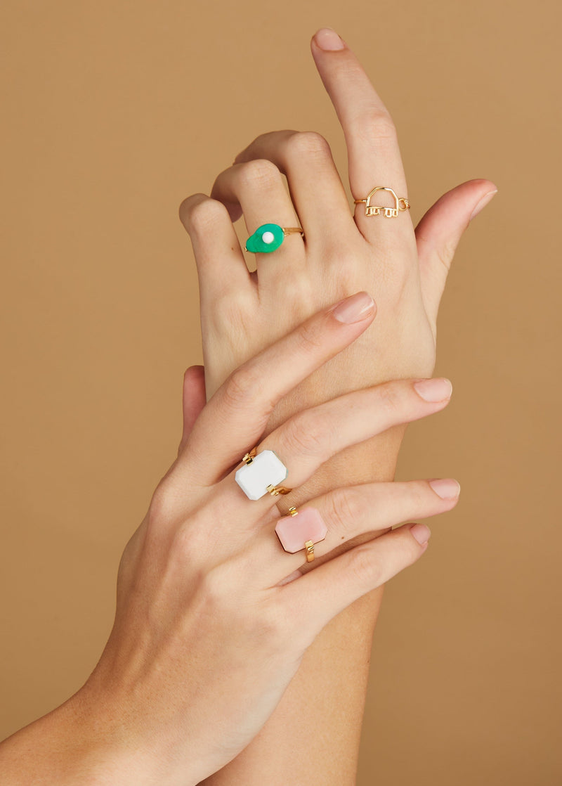 Hands wearing gold rings with turquoise and hard stones