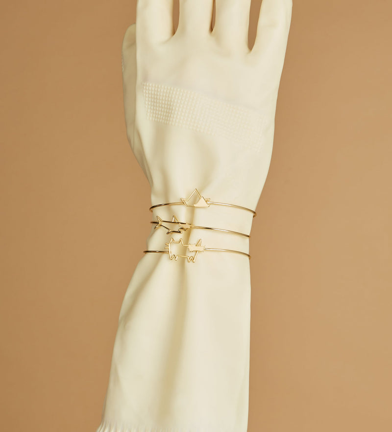 Gold bangle bracelets on gloved hand