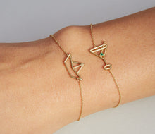 Load image into Gallery viewer, Gold chain bracelets with paper boat and martini drink shaped pendants on model
