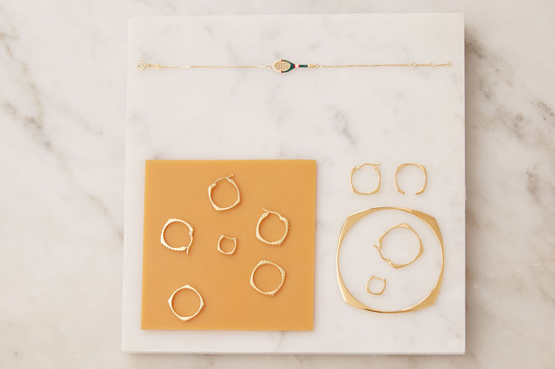 Jewelry composition with gold hoop rings, earrings and bracelets