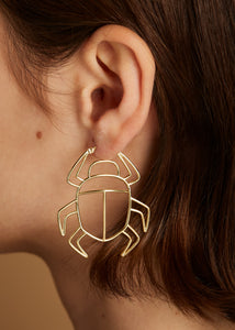 Gold scarab beetle shaped maxi earring worn by model