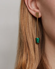 Load image into Gallery viewer, Woman wearing gold long earrings with cylinder cut malachite stone
