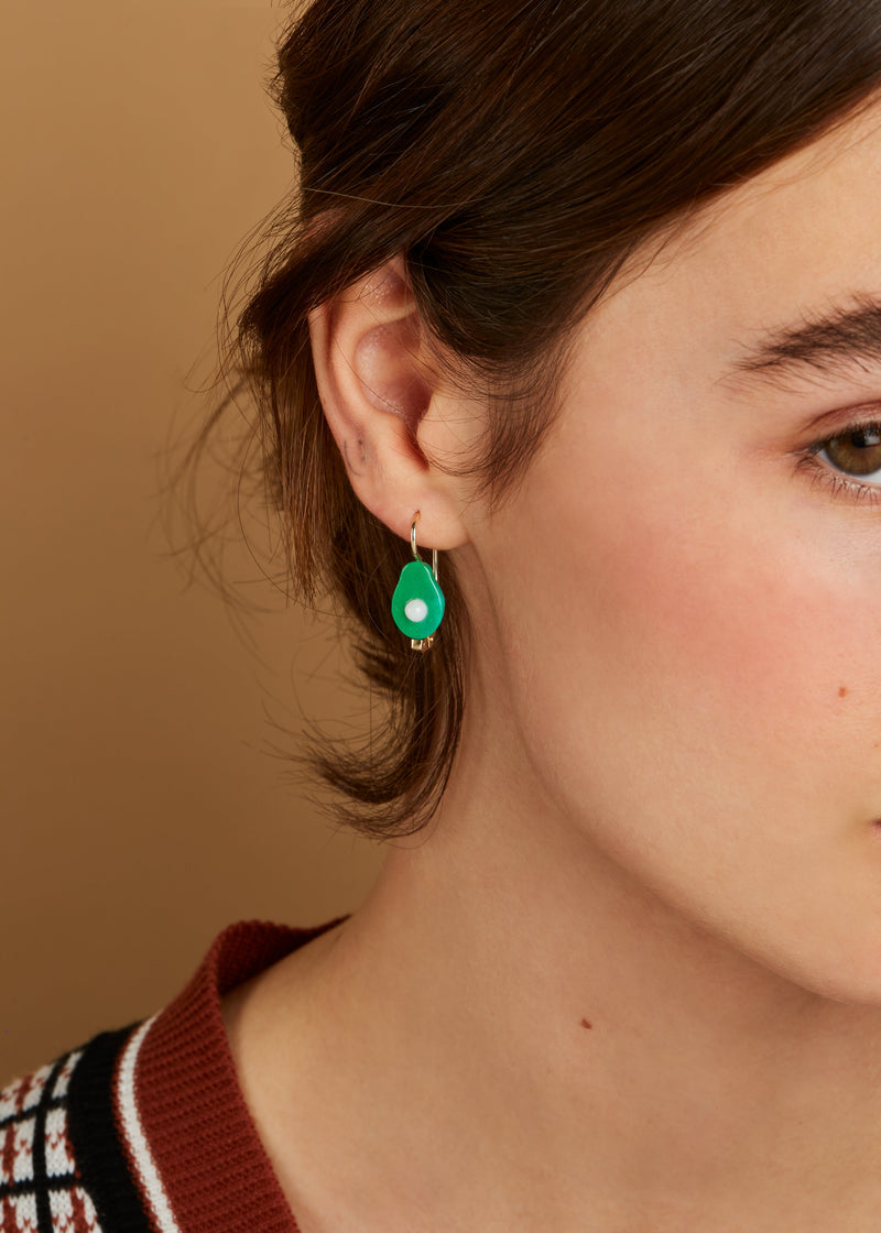 Gold earring with avocado shaped oxidized turquoise and pearl on model