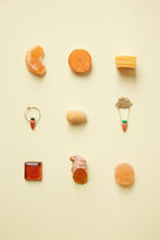 Load image into Gallery viewer, Jewelry and food composition with coral carrot earring and gold necklace
