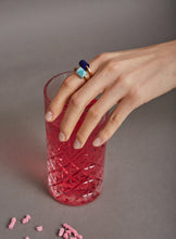 Load image into Gallery viewer, Hand wearing gold rings with amazonite and lapis lazuli stones and pink glass
