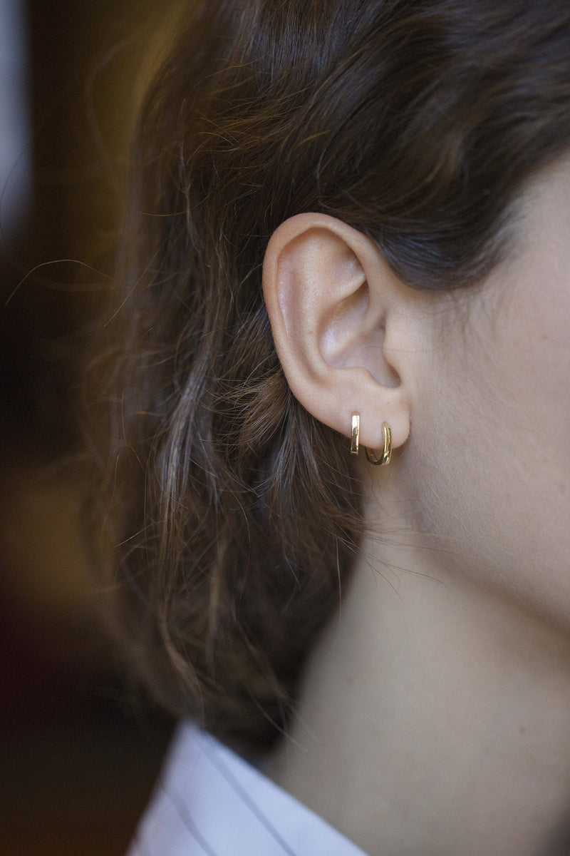 Mini gold hoop earrings worn by model