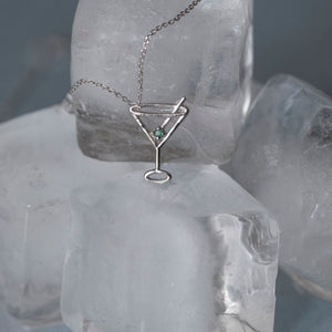 White gold chain necklace with martini drink shaped pendant and small emerald on ice cubes