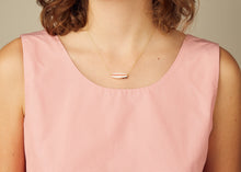 Load image into Gallery viewer, Gold chain necklace with surf shaped white coral pendant worn by model

