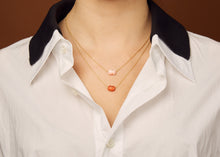 Load image into Gallery viewer, Gold chain necklace with mini pink crab shaped coral pendant worn by model
