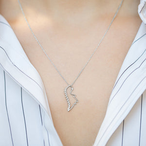 White gold chain necklace with dinosaur shaped pendant worn by model