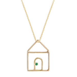 Gold chain necklace with house shaped pendant and small emerald