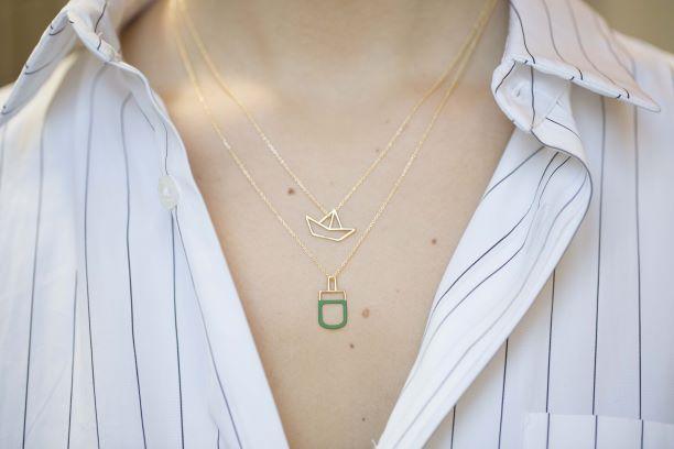 Gold chain necklace with pistachio ice pop pendant worn by model