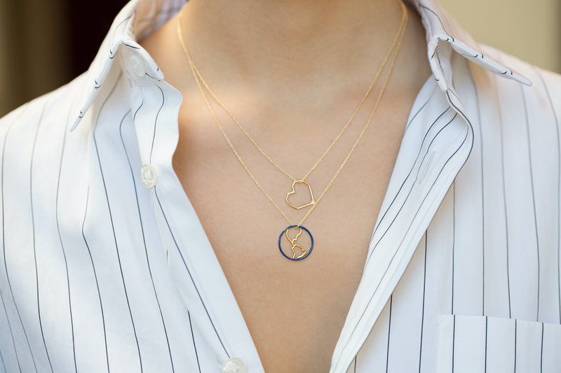Gold chain necklace with earth shaped pedants with blue enamel worn by model