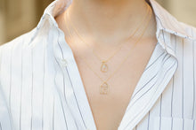 Load image into Gallery viewer, Gold chain necklaces with house and light bulb shaped pendants and small diamond worn by model
