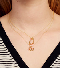 Load image into Gallery viewer, Woman wearing gold chain necklace with a cat shaped pendant with a diamond nose and heart shaped pendant with pink sapphire
