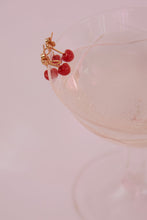 Load image into Gallery viewer, Champagne glass with coral cherries gold earrings on top
