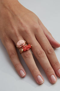 Gold rings with crab and seahorse shaped coral on woman's hand