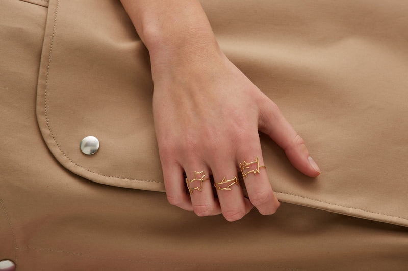 Gold shark shaped ring worn by model