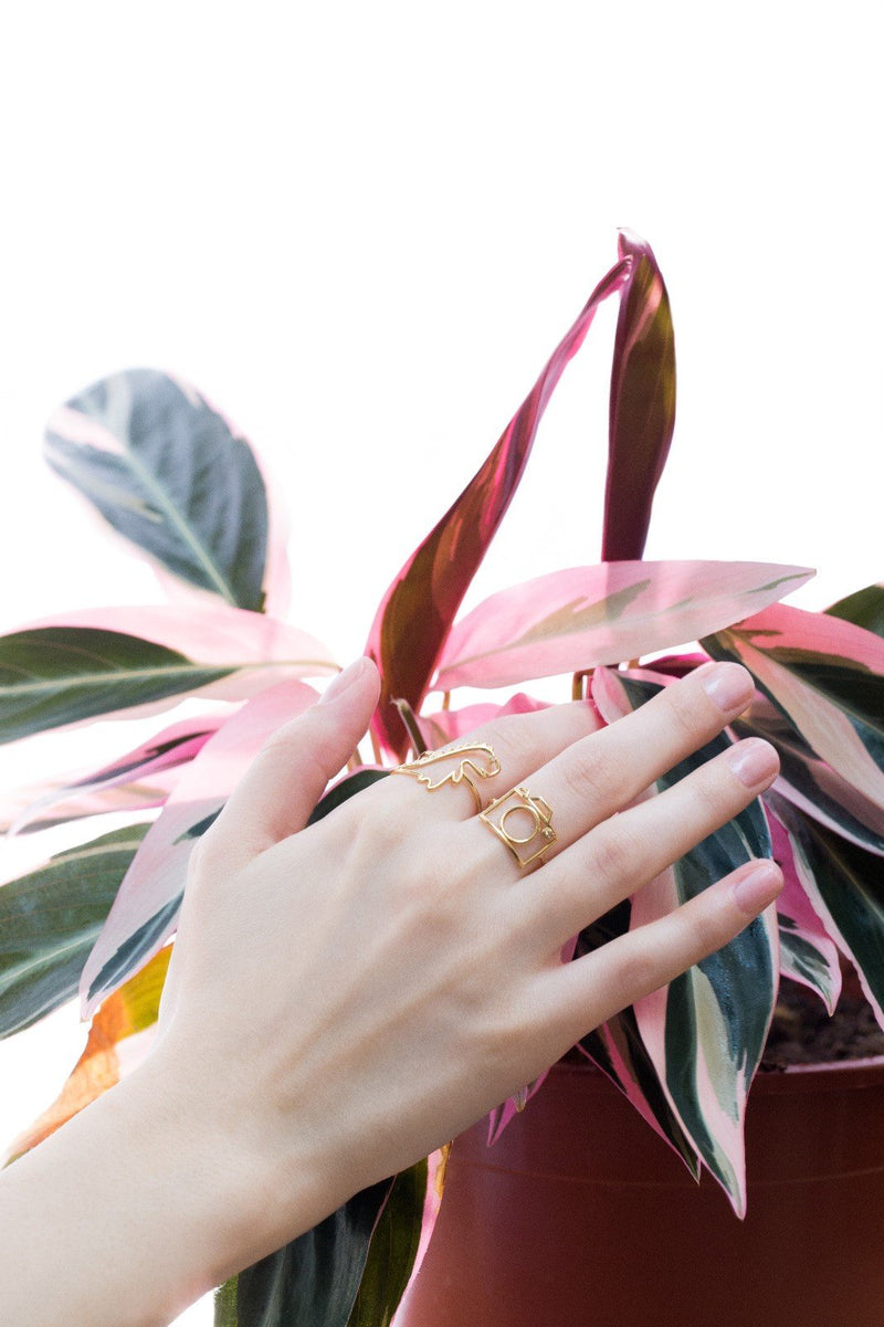 Dinosaur and camera shaped rings with small diamonds on model's hand