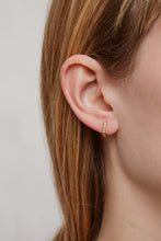 Load image into Gallery viewer, Woman wearing a gold mini hoop earring with a zig-zag finish

