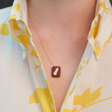 Load image into Gallery viewer, Woman wearing a gold chain necklace with an eggplant shaped cameo made in porcelain
